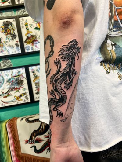 Get inked with a fierce and timeless dragon design by renowned artist River Tatts, showcasing the beauty of traditional tattoo art.