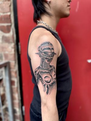 Experience the fusion of man and machine with this traditional black-and-gray robot tattoo by River Tatts. A modern twist on a classic style.