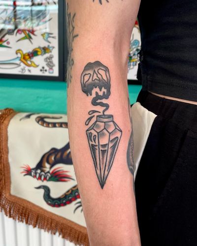 Get inked with a badass traditional tattoo featuring a skull, poison bottle by artist River Tatts.