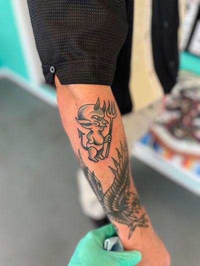 Get inked with a timeless traditional devil design by the talented artist River Tatts. Express your edgy side with this bold and iconic tattoo.