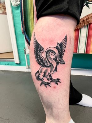 Get inked with this traditional style tattoo featuring a beautiful swan and goose design by the talented River Tatts.