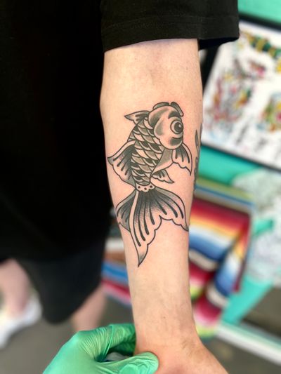 Get a stunning traditional tattoo of a fish, koi, goldfish, or carp done by the talented artist River Tatts. Perfect for those who appreciate intricate designs and bold colors.