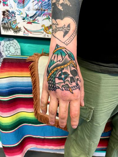 Get a bold and classic traditional skull tattoo by the talented River Tatts. Perfect for those looking for a timeless design with a touch of edge.
