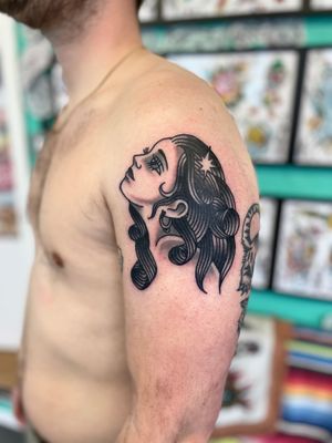 Capture the beauty and strength of a woman with this stunning black and gray traditional tattoo by River Tatts.