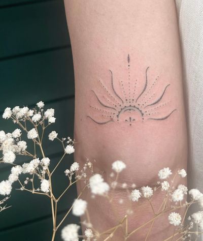 Experience Abbie Lou's skillful dotwork technique and intricate ornamental design in this dainty sun motif tattoo.