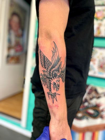 Get a classic traditional eagle tattoo done by the skilled artist River Tatts. Perfect for those who admire the strength and freedom the eagle represents.