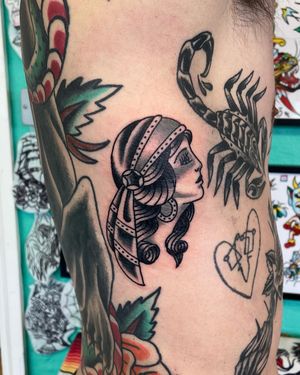 Capture the mystique of a gipsy woman with this bold and timeless traditional tattoo by River Tatts.