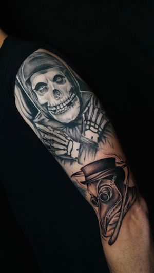 Get inked with Miss Vampira's hauntingly realistic black and gray tattoo featuring a skeleton and plague doctor mask.