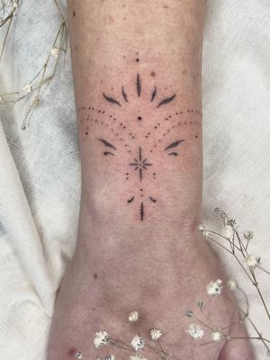 Discover the delicate beauty of this dainty dotwork ornamental tattoo, expertly crafted by artist Abbie Lou.