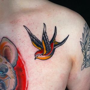 Get a timeless piece with this traditional swallow design by renowned artist Jethro Wood. Perfect for those who appreciate classic tattoo styles.
