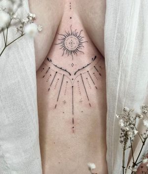 Experience a unique blend of dotwork and intricate hand-poked ornamental design with this sun tattoo by Abbie Lou.