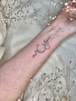 Intricately designed dotwork and fine line hand-poked tattoo of the sacred Ohm symbol by Abbie Lou.