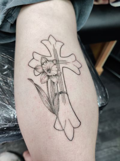 A stunning black and gray tattoo combining dotwork and fine line techniques, featuring a delicate flower intertwined with a graceful cross. By Mary Shalla.