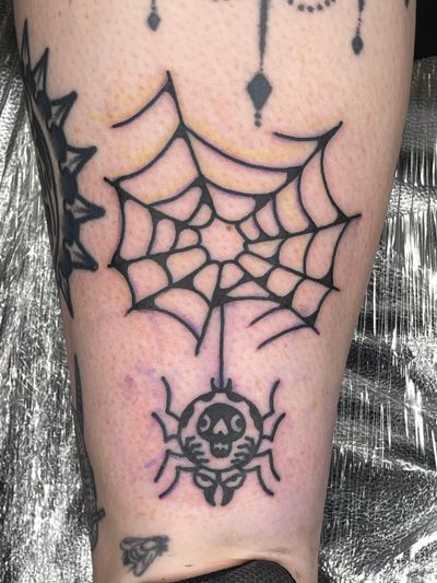 Get tangled in the intricate web of artistry with this traditional spider tattoo by Goblyn Crew.