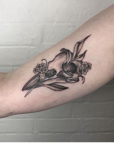 Experience the magic with a unique tattoo featuring a bird, flower, and skull in intricate dotwork style by Claudia Smith.