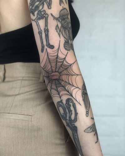 Get a beautifully detailed spider web tattoo in fine line illustrative style by the talented artist Claudia Smith.