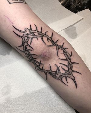 Experience the intricate beauty of dotwork in this illustrative tattoo combining a crown and thorns, expertly crafted by artist Claudia Smith.