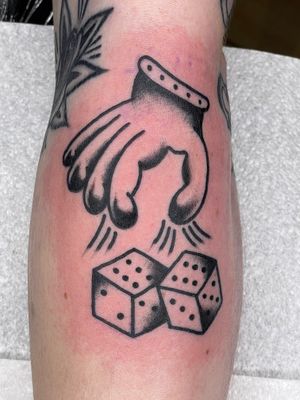 Experience the luck of the draw with this bold and vibrant traditional tattoo featuring a hand and dice. Done by renowned artist Goblyn Crew.