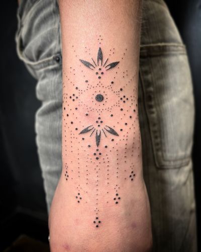 Unique hand-poked design by Indigo Forever Tattoos, combining dotwork and illustrative elements in a beautiful ornamental pattern.