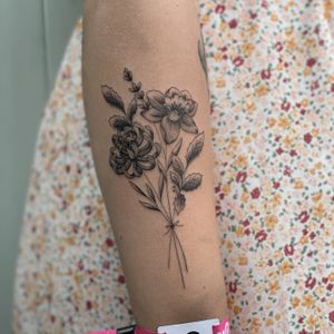 A stunning black and gray floral tattoo featuring a delicate spider lily design, executed with fine line expertise by the talented artist DVA.