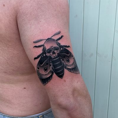 Unique neo traditional tattoo featuring a moth and skull design, expertly executed by DVA.