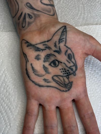 Get this illustrative and edgy pet tattoo by talented artist DVA. Perfect for cat lovers who crave a unique ink experience.