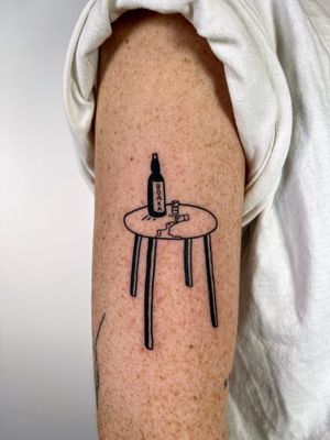Bold and playful illustrative tattoo featuring a table scattered with vodka bottles, shots, and drinks, skillfully inked by Dave Norman.