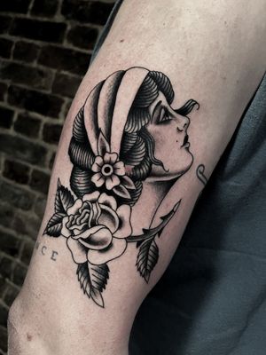 Get a timeless illustrative tattoo of a woman by renowned artist Barney Coles. The perfect blend of classic and modern styles.
