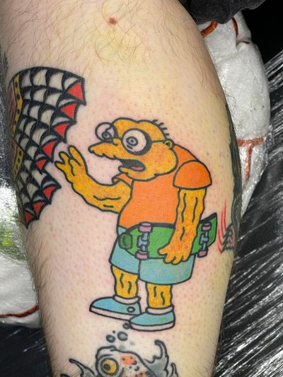 Get a vibrant and playful Simpson's themed tattoo with intricate details by the talented artists at Goblyn Crew. Stand out with this unique piece of art!