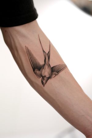 This black and gray illustrative tattoo features a beautiful bird motif, symbolizing freedom and hope. Done by the talented artist Ion Caraman.