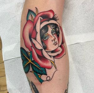 Get a stunning traditional tattoo featuring a beautiful lady and a delicate rose design, expertly done by artist Sam Waiting.