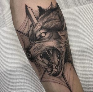 Get a bold blackwork tattoo of a powerful wolf with a sword, expertly executed by tattoo artist Sam Waiting. A stunning and striking design perfect for those who seek strength and courage.