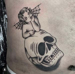 This traditional tattoo by Sam Waiting combines a skull, angel, and cherub motif for a striking and symbolic design.