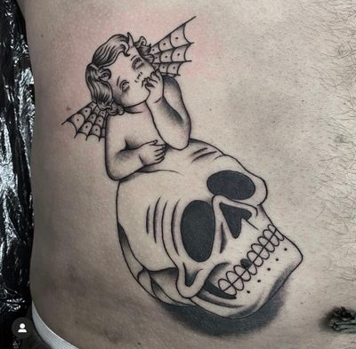 This traditional tattoo by Sam Waiting combines a skull, angel, and cherub motif for a striking and symbolic design.