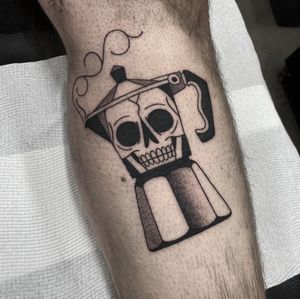 Get inked with a unique black and gray illustrative tattoo of a skull and coffee pot, created by the talented artist Sam Waiting.