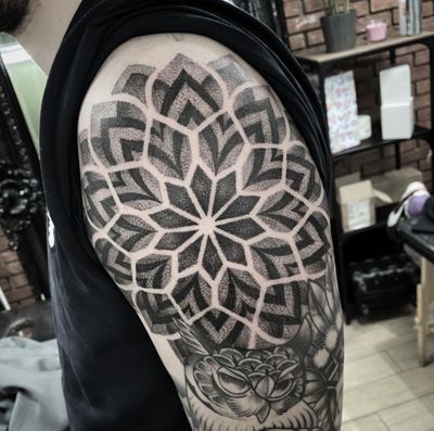 Experience the beauty of geometric dotwork in this stunning mandala tattoo by Sam Waiting. Perfect balance of symmetry and detail.