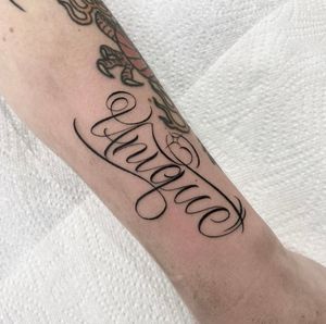 Express your individuality with a one-of-a-kind lettering tattoo by the talented artist Sam Waiting. Perfect for those looking for a small yet impactful design.