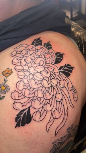 Experience the beauty of a stunning chrysanthemum flower in this illustrative floral tattoo masterpiece by the talented artist Claudia Vicente.