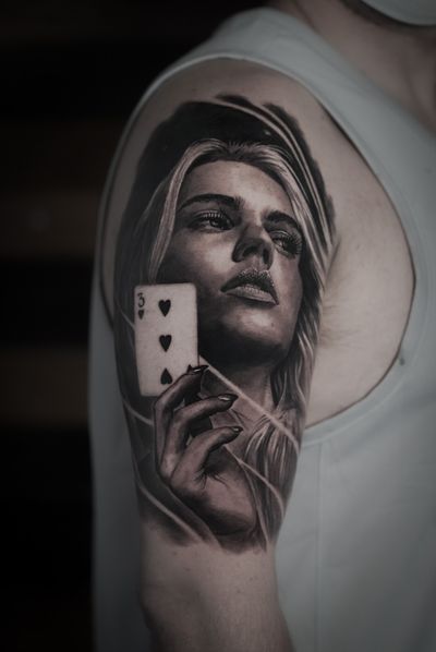 Get inked with a stunning black and gray tattoo featuring a beautiful woman holding a card, created by Milan Boros.