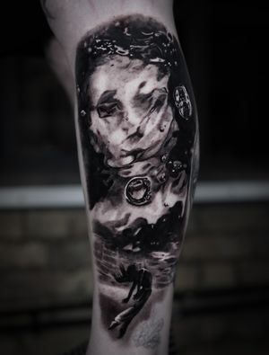Immerse yourself in the dreamlike world of Milan Boros' black and gray tattoo featuring a girl's reflection in a puddle.