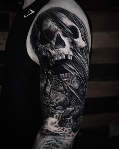 Experience the haunting beauty of Milan Boros' black and gray realism tattoo featuring a grim reaper skull motif.
