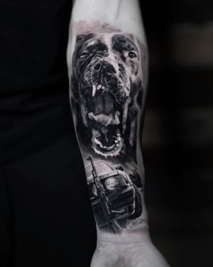 Experience Milan Boros' impeccable black and gray realism with this chicano-inspired tattoo featuring a dog and gun motif.