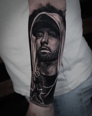 Get a stunning black and gray realism tattoo of Eminem's portrait done by talented artist Milan Boros.