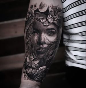 Experience the beauty of nature with this stunning black and gray tattoo featuring a realistic butterfly and a elegant lady. Created by renowned artist Milan Boros.