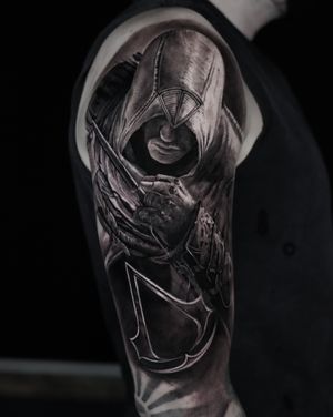 Immerse yourself in the gaming world with this striking black and gray tattoo by Milan Boros.