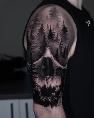 Get lost in the haunting beauty of this black and gray tattoo by Milan Boros. A skull emerges from a mystical forest, capturing the essence of life and death.