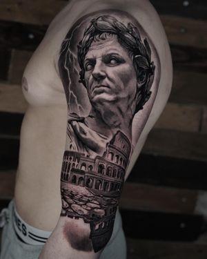 Capture the essence of ancient Rome with this stunning black and gray tattoo featuring a realistic portrayal of a Caesar statue and the Colosseum.