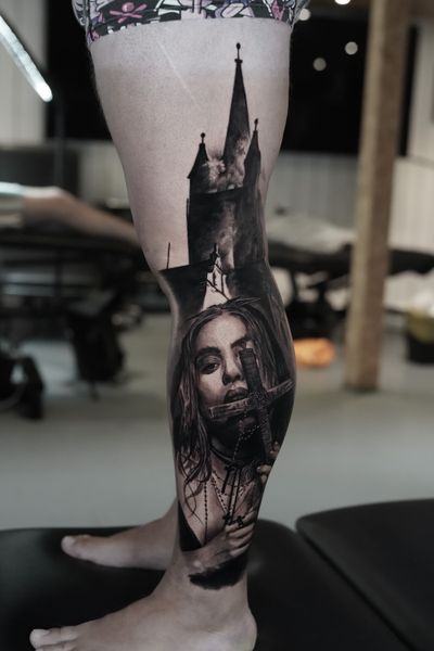 Stunning black and gray realism tattoo featuring a detailed cross and castle with a mysterious woman, by the talented Milan Boros.
