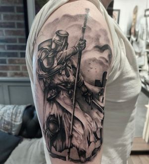 Experience the valor and bravery of a knight on a crusade in this stunning black and gray realism tattoo by artist Tom Boxell.