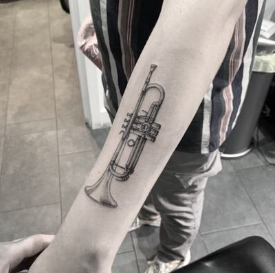 Get lost in the melody with this striking black and gray trumpet tattoo by Tom Boxell. Perfect for music lovers.